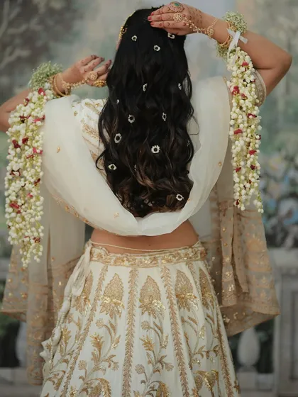 A beautiful back view showing how the floral kalire and hair accessories come together. The flowers are woven into the bride's hair to create a cohesive and ethereal style.