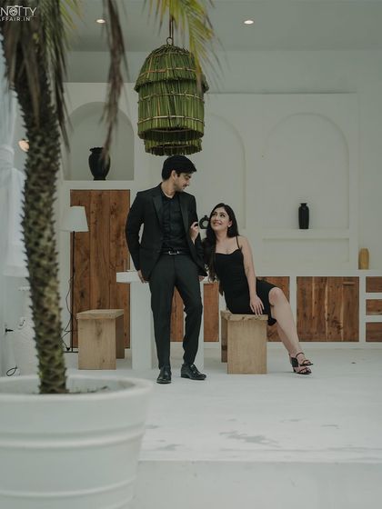 A stylish portrait in a modern, minimalist setting. The composition uses the surrounding decor to create a visually interesting and chic pre-wedding photo.