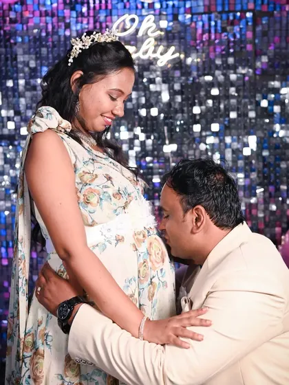 A classic and heartwarming moment from a baby shower where the dad-to-be kisses the baby bump. It’s a beautiful expression of his love and excitement, captured against the fun, celebratory backdrop of their party.