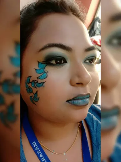 Unleash your inner artist with our fantasy makeup classes. This student created a stunning look with a monochromatic blue theme, featuring smokey eyes, a matching lip, and hand-painted glittery leaf details on the cheek.