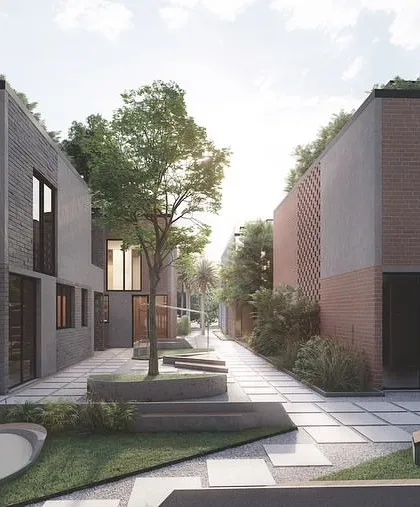 A view of a pedestrian-friendly lane within the Kolgaon Masterplan, flanked by townhouses with varied material palettes. The central green space with integrated seating and art creates a focal point for the neighborhood cluster.