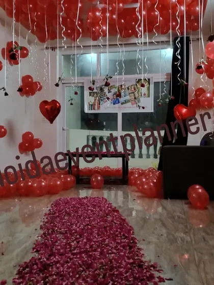 A full room view of a proposal decoration, showing how we use balloons on the floor and ceiling, along with a rose petal path, to completely transform a space.
