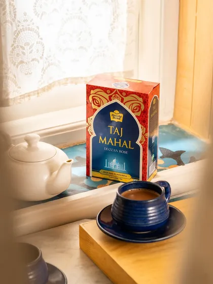 A product shot for Taj Mahal Tea, styled to create a cozy, at-home tea time scene by a window.