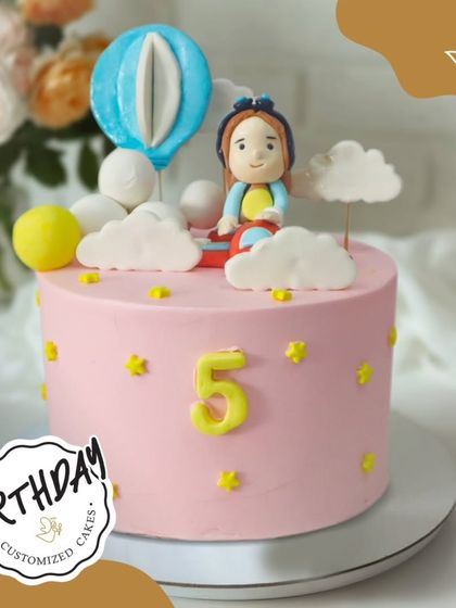 A dreamy cake with a hot air balloon floating among the clouds. This whimsical pink cake is perfect for a little adventurer's 5th birthday.