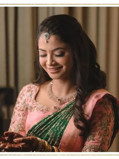 A beautiful, candid shot of the bride. Her smile is genuine, and her soft, natural makeup enhances her features without looking heavy, creating a timeless and elegant look.