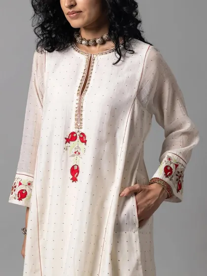 Minimal yet majestic. This close-up shows the delicate pomegranate motifs embroidered on the cuffs and bodice of this classic white kurta.