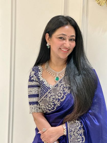A close-up of the guest, highlighting the detailed silver embroidery on her blouse and her sparkling diamond jewelry.