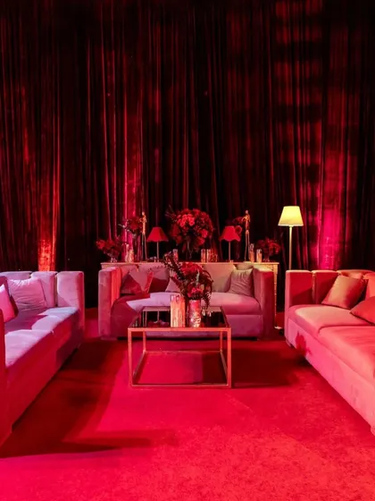 I created multiple lounge areas using contemporary velvet sofas in muted tones, allowing the intense red of the surrounding decor and lighting to remain the hero of the space.
