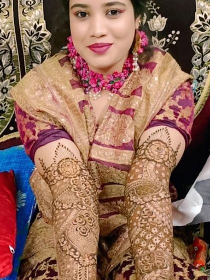 A lovely portrait of the bride, showing the intricate henna design on both of her arms. The patterns are traditional and timeless.