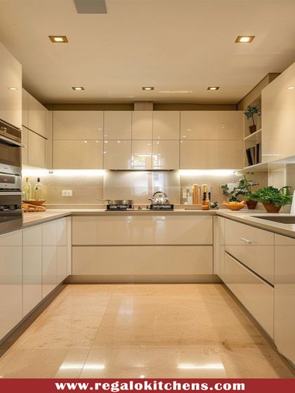 A spacious U-shaped kitchen with high-gloss cream cabinets and a polished marble floor. The layout is perfect for those who love to cook, offering extensive counter space and storage. Spotlights and under-cabinet lighting create a bright, inviting atmosphere.