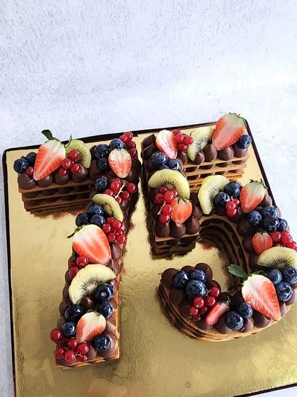 Our cream tart cakes are a great alternative to a traditional cake. This one, in the shape of the number 75, is layered with chocolate cream and topped with fresh berries.