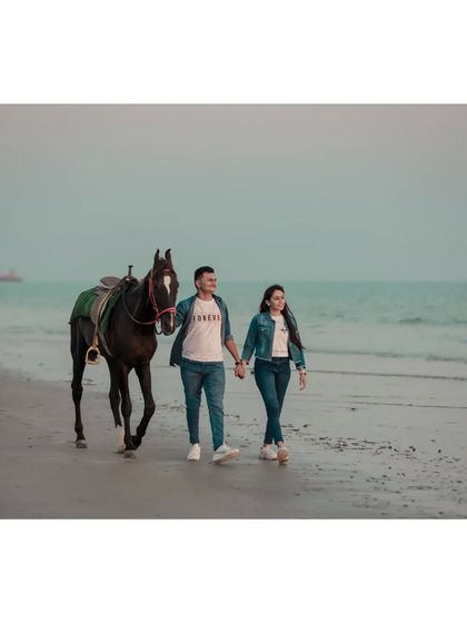 A romantic pre-wedding walk on the beach with a horse, capturing a unique and storybook-like moment for the couple.