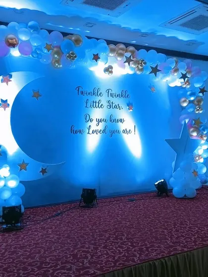 For a magical celebration, we designed this "Twinkle Twinkle Little Star" baby shower stage. The deep blue lighting, crescent moon prop, and cloud-like balloon arrangements create a dreamy atmosphere that guests love.