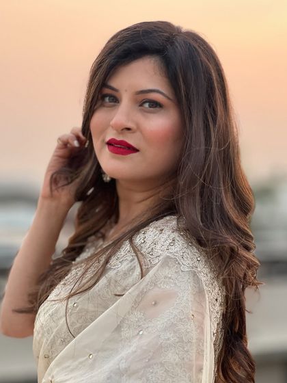 A close-up of Savaniee's glamorous look. The bold red lip is the statement piece, paired with soft, shimmering eye makeup.