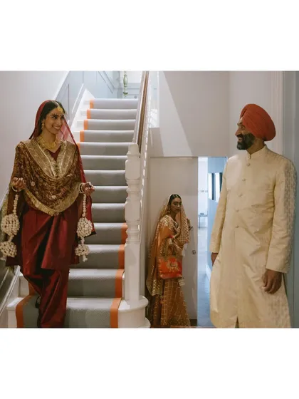 A father looks on as his daughter descends the stairs, ready for her Anand Karaj ceremony. It’s a quiet moment of pride and love, beautifully captured in the family home.