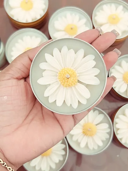 A close-up of our daisy tin candle. It's a charming keepsake for your guests to cherish long after your event.