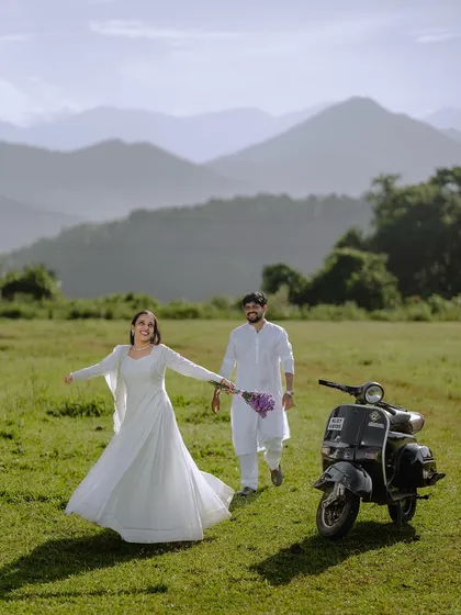 A playful "follow me" shot, with her leading him through the field. The scooter adds a unique, story-telling element.