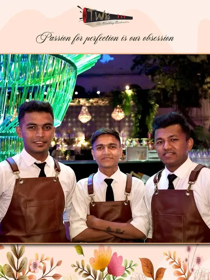 Our team of bartenders in smart leather aprons, standing proudly before a stunning bar setup at a Sangeet in Udaipur.