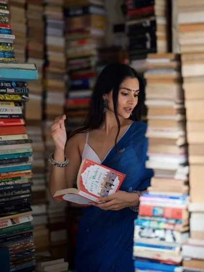 A storytelling shot of me engrossed in a book, surrounded by the magical chaos of the bookstore.