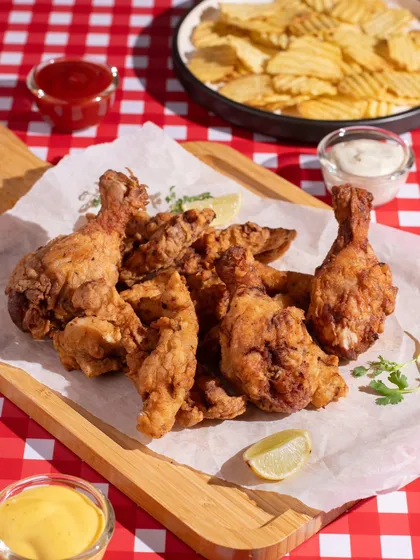 A classic platter of fried chicken and chips. The bright, picnic-style setup makes it look fun and inviting.