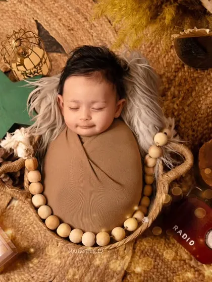 A similar top-down shot of another baby in the same boho basket setup, showing how we customize small details for each session.