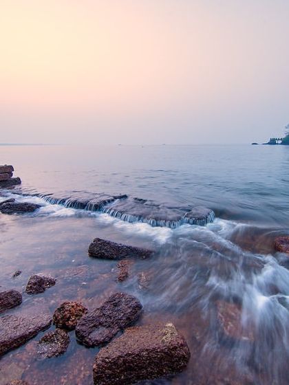 The ruins of a stone structure on a beach in Goa, with the water flowing around it. This long exposure captures the interaction between the man-made and the natural.