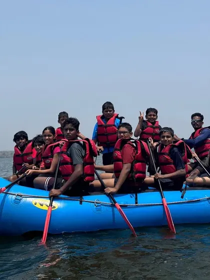 A happy group of summer campers poses for a photo in a raft on the clear waters of Vani Vilas Sagar.
