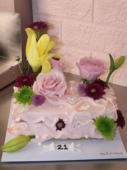 Rectangle cakes have entered the chat. This new shape is perfect for our cottagecore designs, like this pink cake adorned with a beautiful arrangement of fresh flowers.