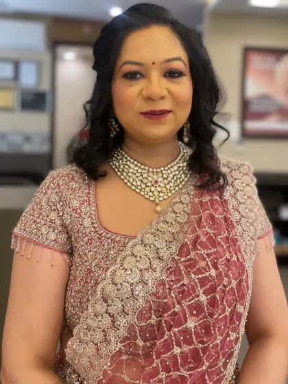 I believe in creating looks that are timeless and elegant for every client. This party makeup features a beautiful pink eyeshadow, defined liner, and a bold red lip, perfectly coordinated with her traditional attire.