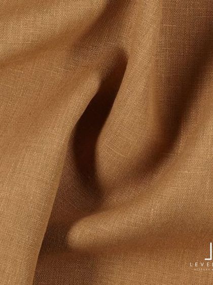 A close-up of a rich, camel-colored linen fabric, highlighting its natural texture and beautiful drape.