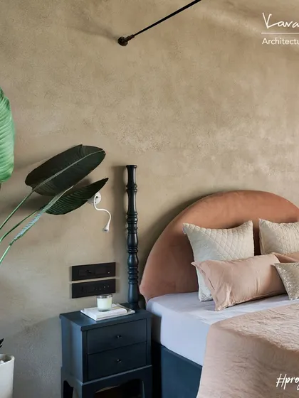 A detail of the master bedroom in the Red Fort Project, showing the bedside table and the textured wall finish. The combination of soft colors and natural materials creates a peaceful and calming environment.