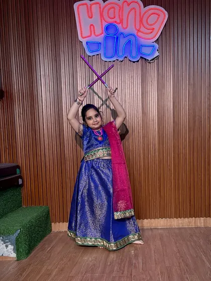 Holding her dandiya sticks in a classic pose, this student in a royal blue lehenga is ready for the dance floor. Our classes focus on teaching authentic steps and postures.