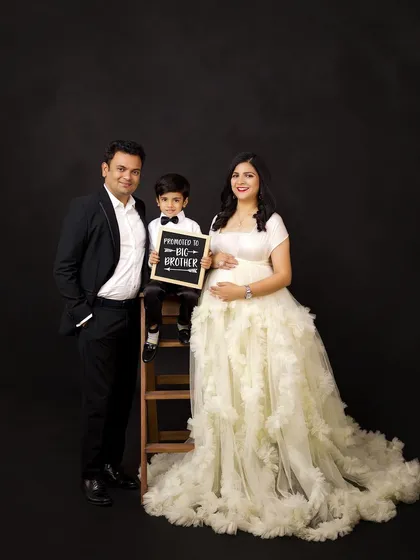Your maternity session can be a celebration for the whole family. Including older siblings is a wonderful way to capture their excitement, like this proud big brother-to-be announcing his promotion. These are the moments your family will treasure forever.