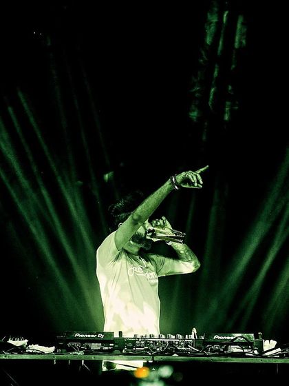 Pointing to the crowd under green spotlights. It's a simple gesture, but it's how I connect with people and make them feel part of the show.