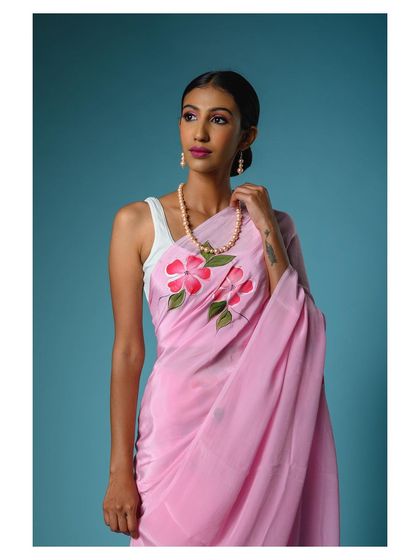 A portrait-style shot that brings attention to the neckline and the way the pink saree is draped, along with the complementary jewelry.