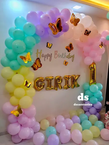 A close-up of the pastel butterfly-themed balloon arch, showcasing the delicate color palette and placement of the gold butterfly accents.
