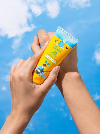A dynamic hand shot showing the application of sunscreen. The hands and product are set against a vibrant sky, creating a feeling of freedom and protection for sunny days.
