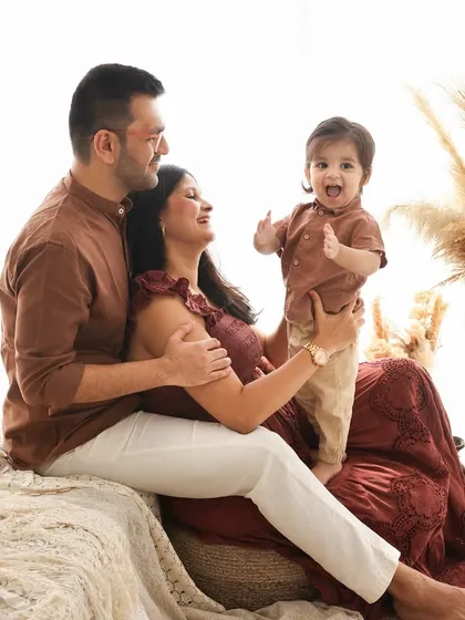 A picture of pure happiness. This family portrait, set against a bright and airy boho backdrop, is full of laughter and love. The coordinated outfits and natural smiles make it a perfect keepsake.
