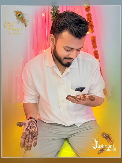 A different angle of the groom looking at his detailed henna art.