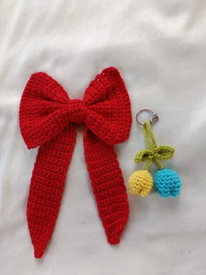 A classic red crochet hair bow paired with a custom tulip keychain. I love creating matching or coordinated sets for my clients.
