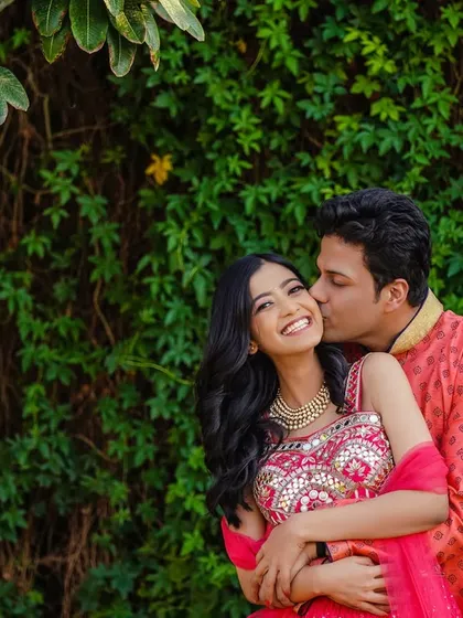 A sweet kiss on the cheek. This photo is filled with tenderness and affection, a perfect candid moment showing the couple's love.