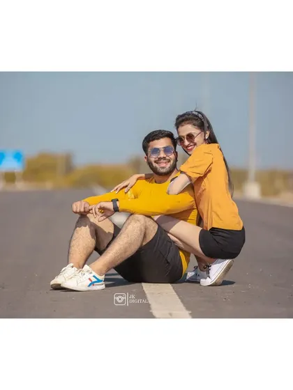 A fun and relaxed pose on an open road for Raj and Hiral's shoot. This casual style is great for capturing a couple's playful personality.