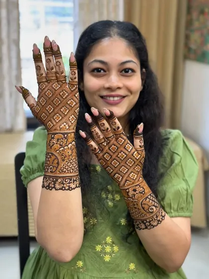 This client is all smiles with her full-hand jaali pattern mehndi.
