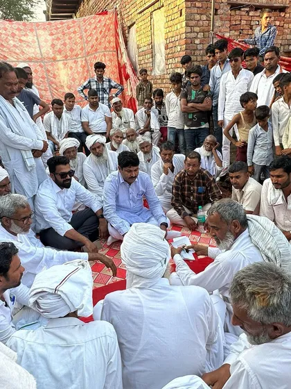 Deep in conversation with village elders during a community function in the Nuh assembly area. Understanding local traditions and participating in them is key to effective representation.