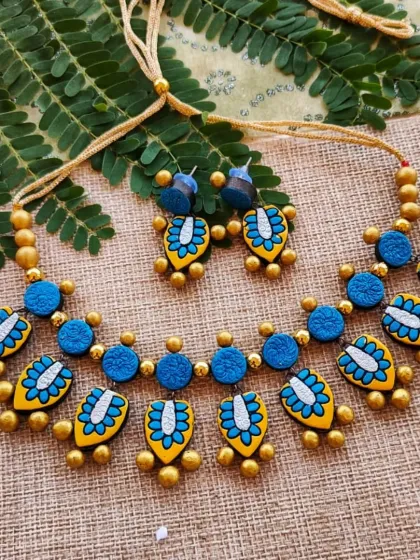 The same two-layer leaf-patterned necklace, here in a striking blue, gold, yellow, and silver combination.