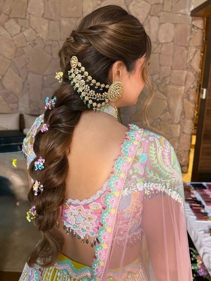 A side view of the modern bubble plait, showing how the small floral accessories and large ear cuff create a balanced look.
