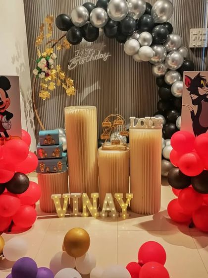 A closer look at the Tom & Jerry and Mickey Mouse themed birthday party. The black and silver balloon arch provides a nice contrast to the colorful characters.
