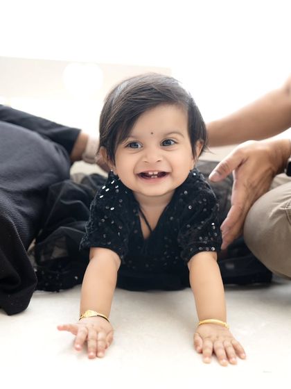 A joyful crawling baby with a big, toothy grin. Capturing these happy milestones is what it's all about.