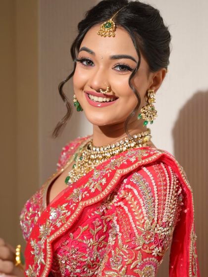 A breathtaking bridal look in a vibrant red lehenga. Her happy smile and radiant glow make this a perfect inspiration for any bride-to-be.