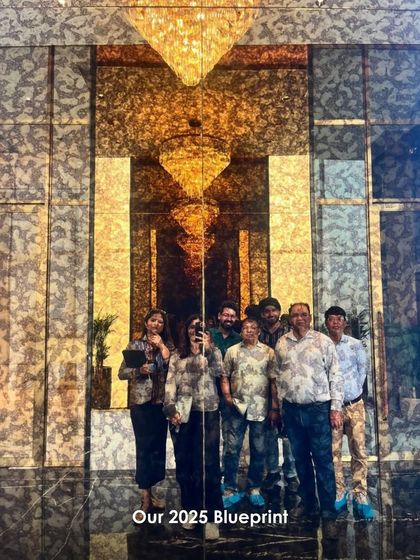 A photo of our team on a site visit, standing before a grand, reflective wall. This image captures the collaborative spirit and hands-on approach we bring to every project.